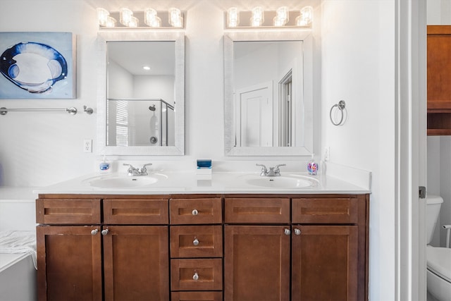 bathroom featuring a sink, toilet, a stall shower, and double vanity