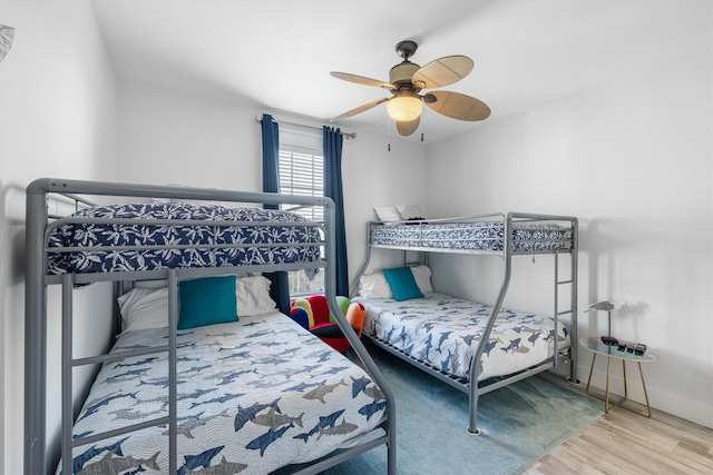 bedroom with wood finished floors, baseboards, and ceiling fan