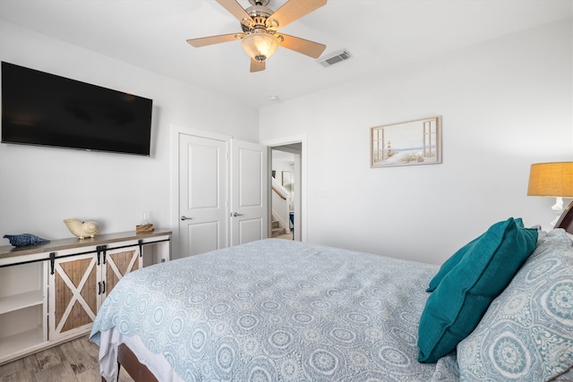 bedroom featuring visible vents, wood finished floors, and a ceiling fan