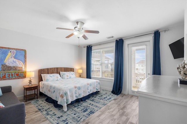 bedroom featuring visible vents, baseboards, light wood-style flooring, and access to outside