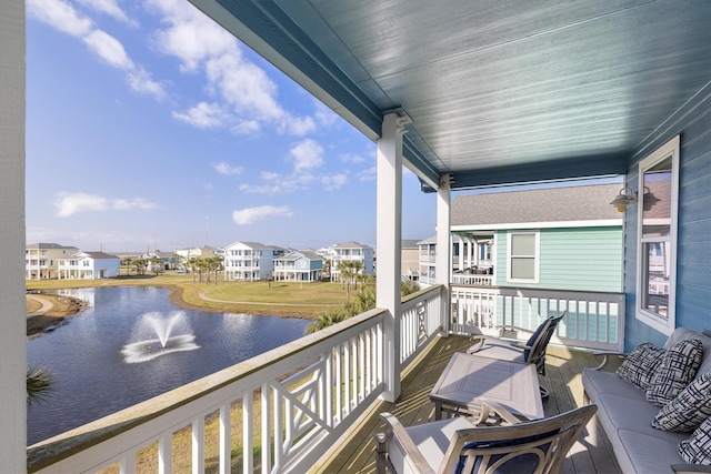 balcony featuring a residential view and a water view