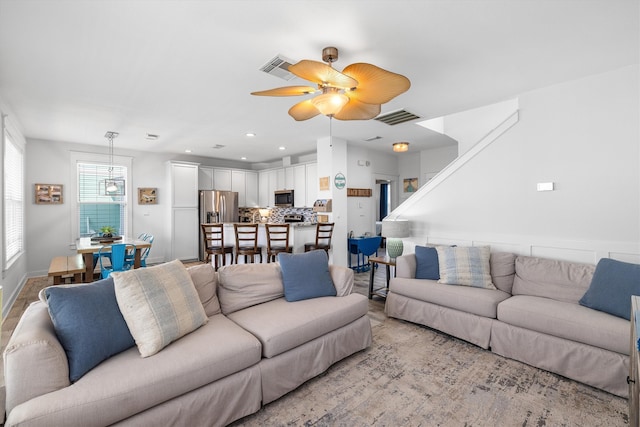 living area with recessed lighting, visible vents, and ceiling fan