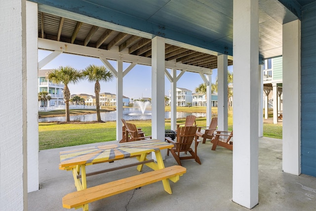 view of patio / terrace with a residential view and a water view