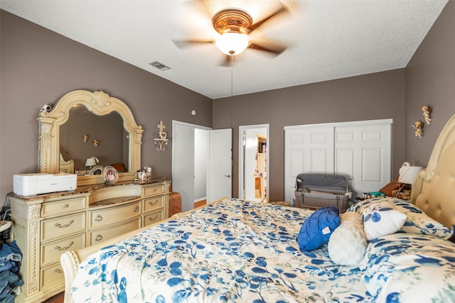 bedroom with a textured ceiling, a ceiling fan, visible vents, and connected bathroom