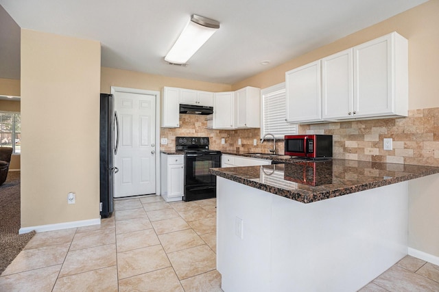 kitchen featuring a peninsula, freestanding refrigerator, a sink, white cabinets, and black range with electric stovetop