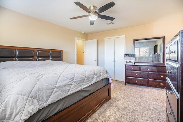 bedroom with visible vents, light colored carpet, a closet, and ceiling fan