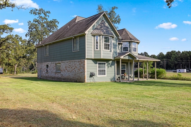 back of house with brick siding, a lawn, and a patio area