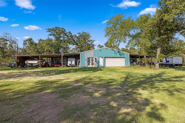 view of front of house featuring a front yard, a garage, a pole building, an outdoor structure, and driveway