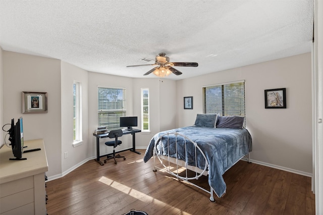 bedroom featuring baseboards, visible vents, dark wood-style flooring, and a textured ceiling