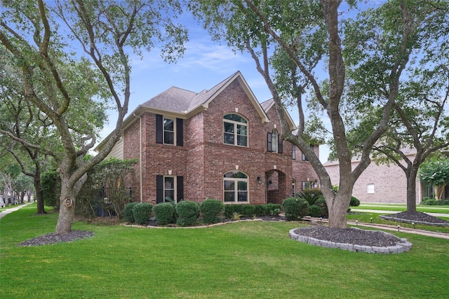 view of front facade featuring brick siding and a front lawn