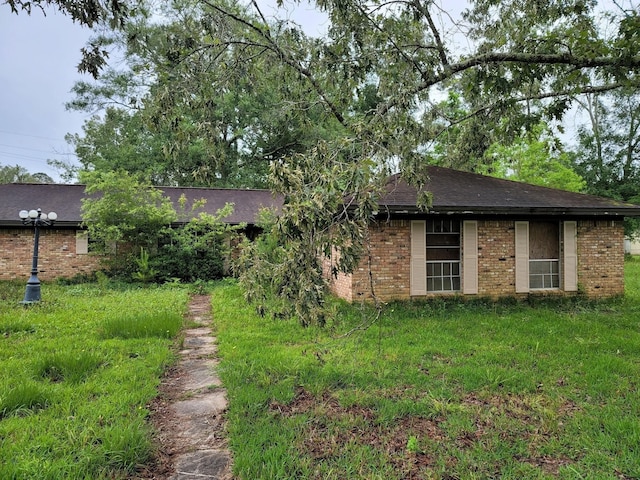 view of side of home with brick siding and a shingled roof