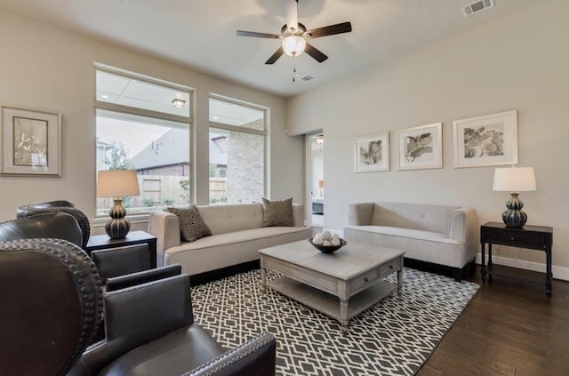 living area with a ceiling fan, wood finished floors, visible vents, and baseboards