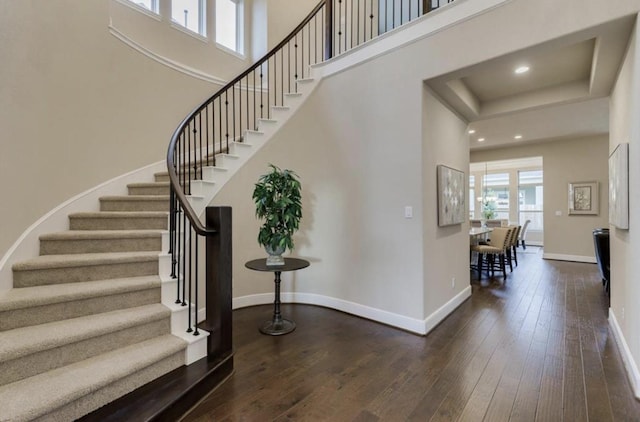 entryway featuring baseboards, a high ceiling, and hardwood / wood-style floors