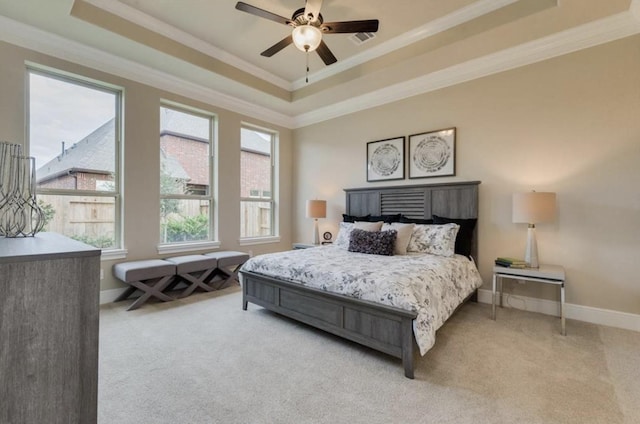 bedroom featuring a raised ceiling, crown molding, and light colored carpet