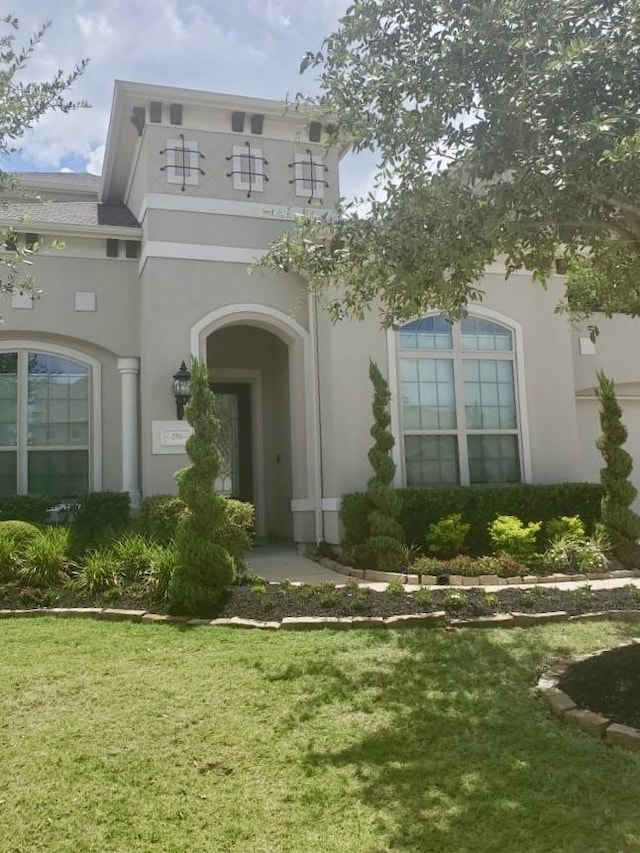 exterior space featuring stucco siding and a yard