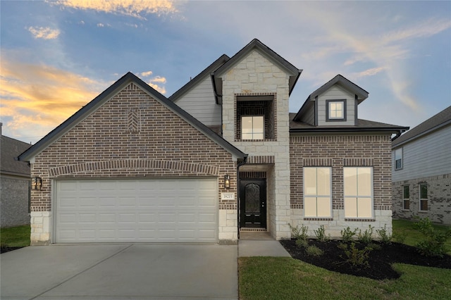 french provincial home featuring brick siding, stone siding, driveway, and a garage