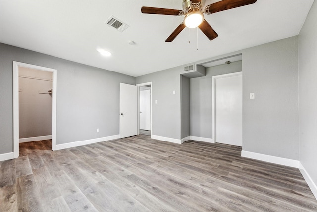 unfurnished bedroom featuring visible vents, baseboards, and wood finished floors