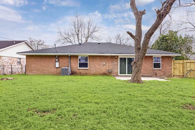 rear view of house featuring a patio, central AC, fence, a yard, and brick siding