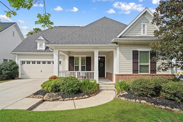 view of front of property with brick siding, a shingled roof, covered porch, a garage, and driveway