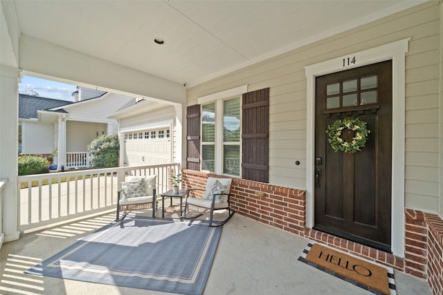 view of exterior entry featuring brick siding and covered porch