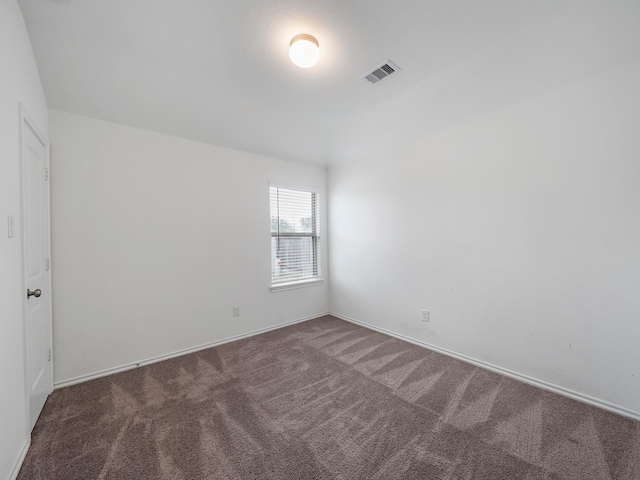 carpeted spare room featuring visible vents