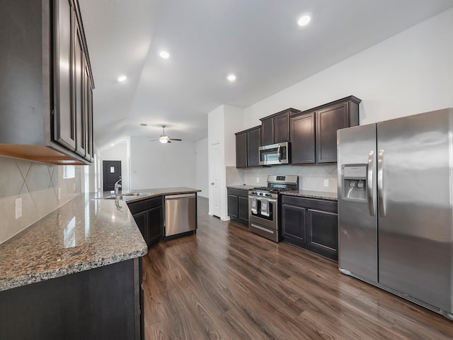 kitchen featuring a ceiling fan, a sink, dark wood-style floors, appliances with stainless steel finishes, and decorative backsplash