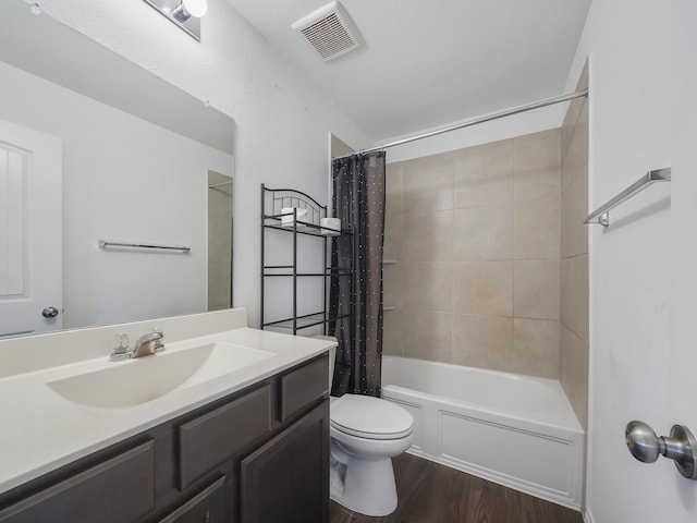 bathroom with visible vents, toilet, shower / tub combo with curtain, wood finished floors, and vanity