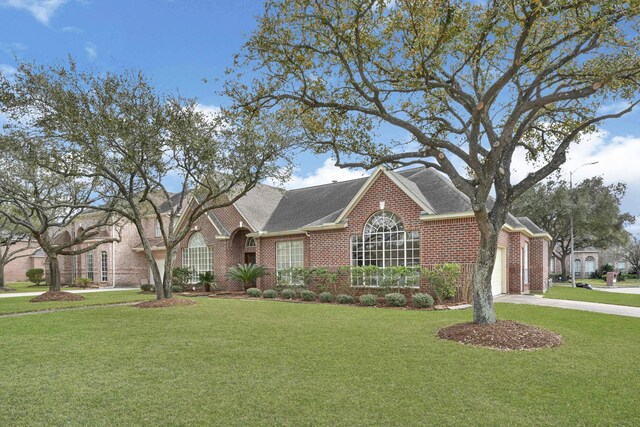 7419 Place Vendome, Spring, TX 77379 - view of front of property with brick siding, a front yard, driveway, an attached garage, and roof with shingles