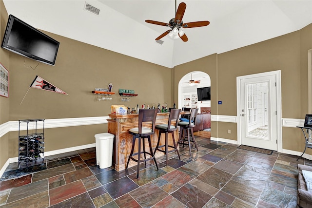 7419 Place Vendome, Spring, TX 77379 - indoor dry bar featuring a ceiling fan, stone tile floors, baseboards, and a towering ceiling