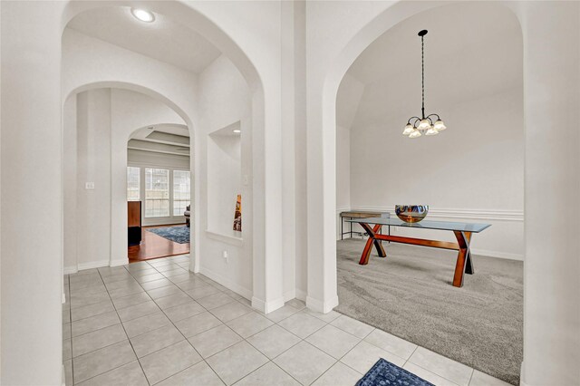 7419 Place Vendome, Spring, TX 77379 - corridor with light tile patterned floors, arched walkways, light carpet, a chandelier, and baseboards