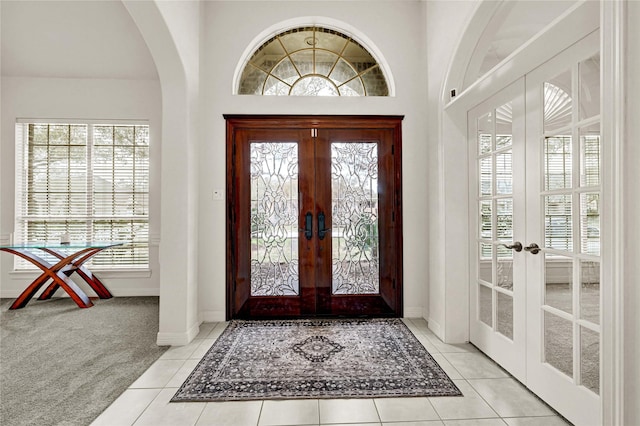 7419 Place Vendome, Spring, TX 77379 - foyer entrance with french doors, arched walkways, baseboards, carpet, and tile patterned flooring