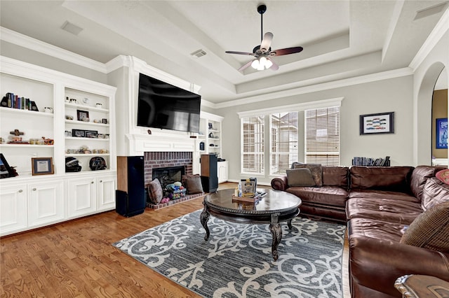 7419 Place Vendome, Spring, TX 77379 - living area with ceiling fan, wood finished floors, a tray ceiling, a fireplace, and arched walkways