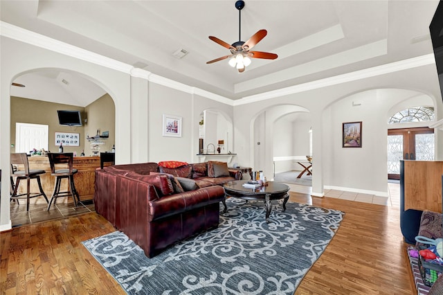 7419 Place Vendome, Spring, TX 77379 - living room featuring arched walkways, a tray ceiling, a ceiling fan, and wood finished floors