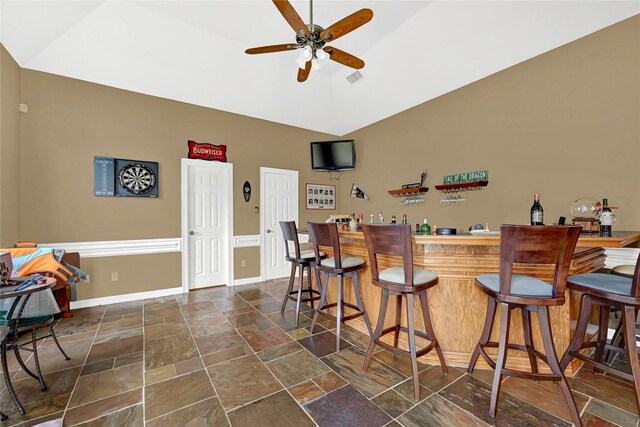7419 Place Vendome, Spring, TX 77379 - indoor bar featuring stone tile floors, ceiling fan, vaulted ceiling, and baseboards