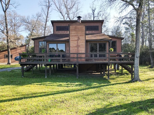 back of property featuring a yard, a wooden deck, and a shingled roof