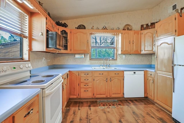 kitchen featuring visible vents, light countertops, lofted ceiling, white appliances, and a sink