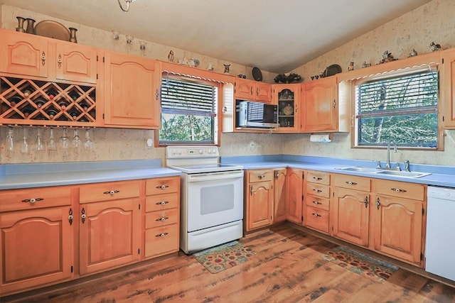 kitchen with light countertops, vaulted ceiling, dark wood-style floors, white appliances, and a sink