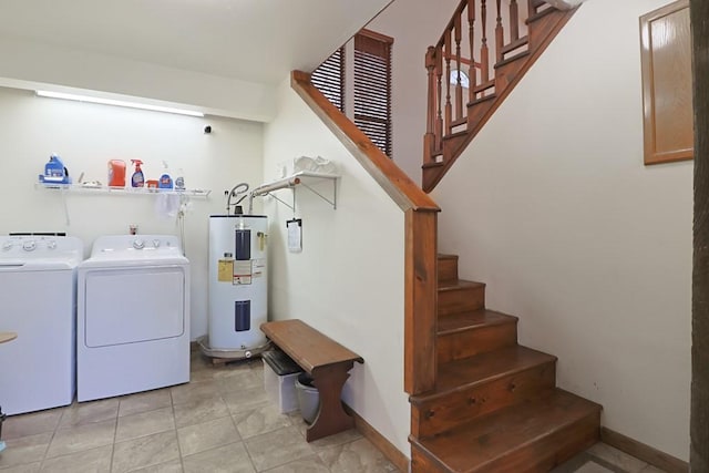 clothes washing area featuring washer and dryer, light tile patterned floors, baseboards, and water heater