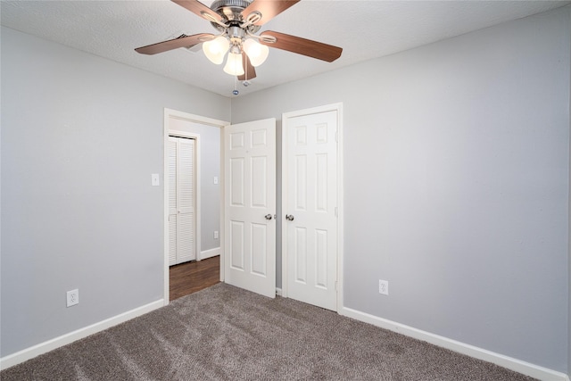 unfurnished bedroom featuring ceiling fan, baseboards, carpet flooring, a closet, and a textured ceiling