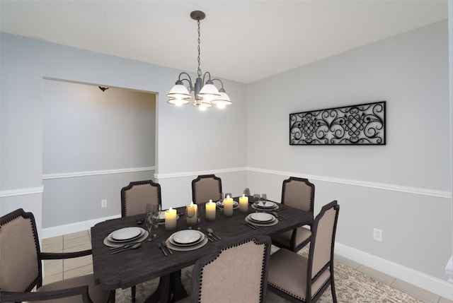 dining area with baseboards, a notable chandelier, and tile patterned flooring