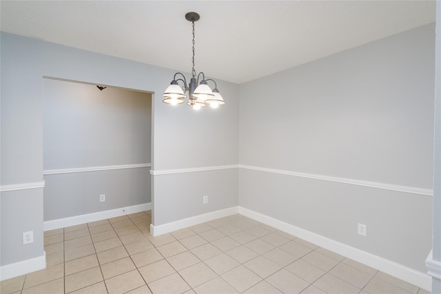 spare room with light tile patterned floors, baseboards, and a notable chandelier