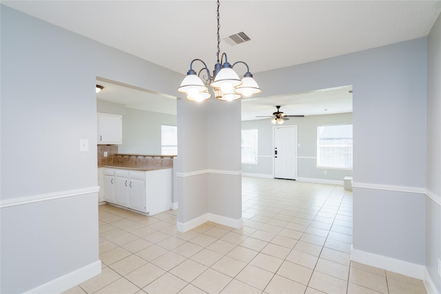 spare room featuring light tile patterned floors, visible vents, plenty of natural light, and baseboards