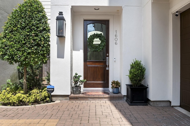 doorway to property featuring stucco siding