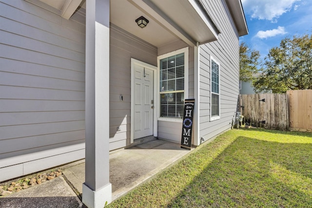 property entrance featuring a yard and fence