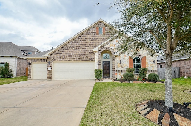 view of front of property featuring driveway, brick siding, an attached garage, and a front yard