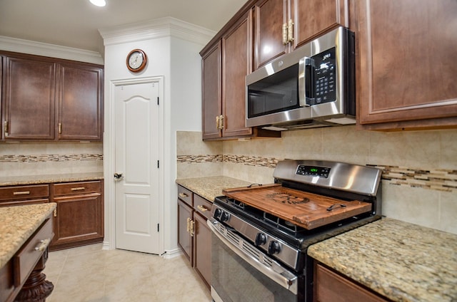 kitchen with tasteful backsplash, stainless steel appliances, crown molding, and light stone countertops