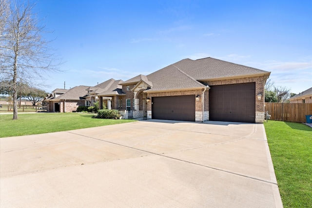 view of front of house with a front yard, fence, concrete driveway, a garage, and brick siding