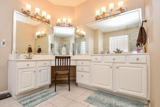 bathroom featuring tile patterned flooring, vanity, and a tile shower