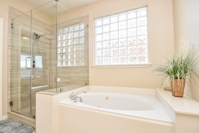 bathroom featuring a shower stall and a garden tub