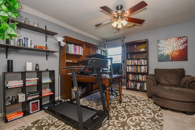 carpeted home office with a ceiling fan, visible vents, and a textured ceiling